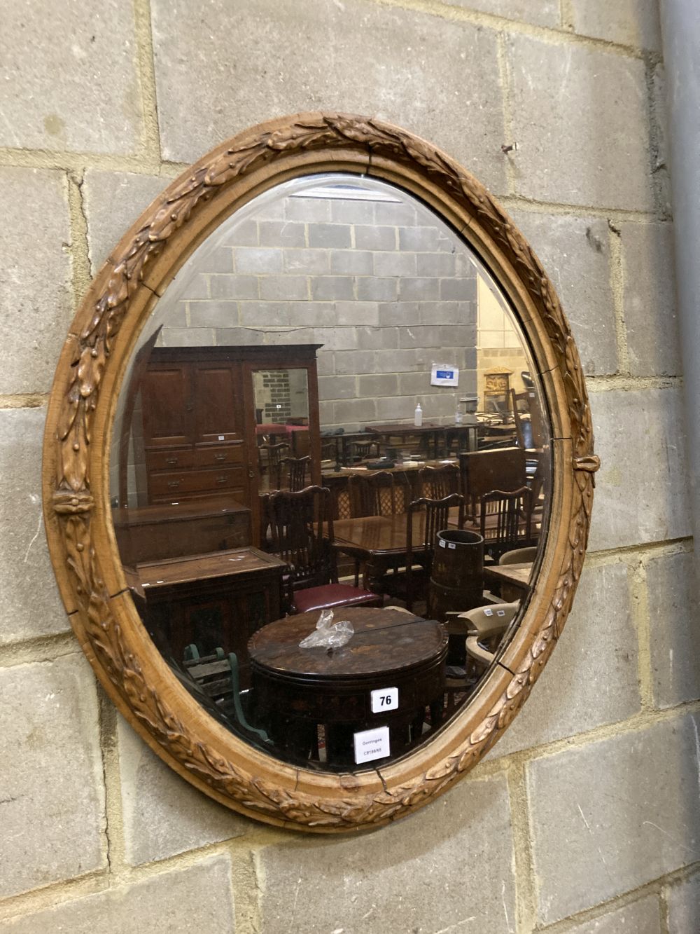 An oval laurel carved mirror, width 64cm height 75cm